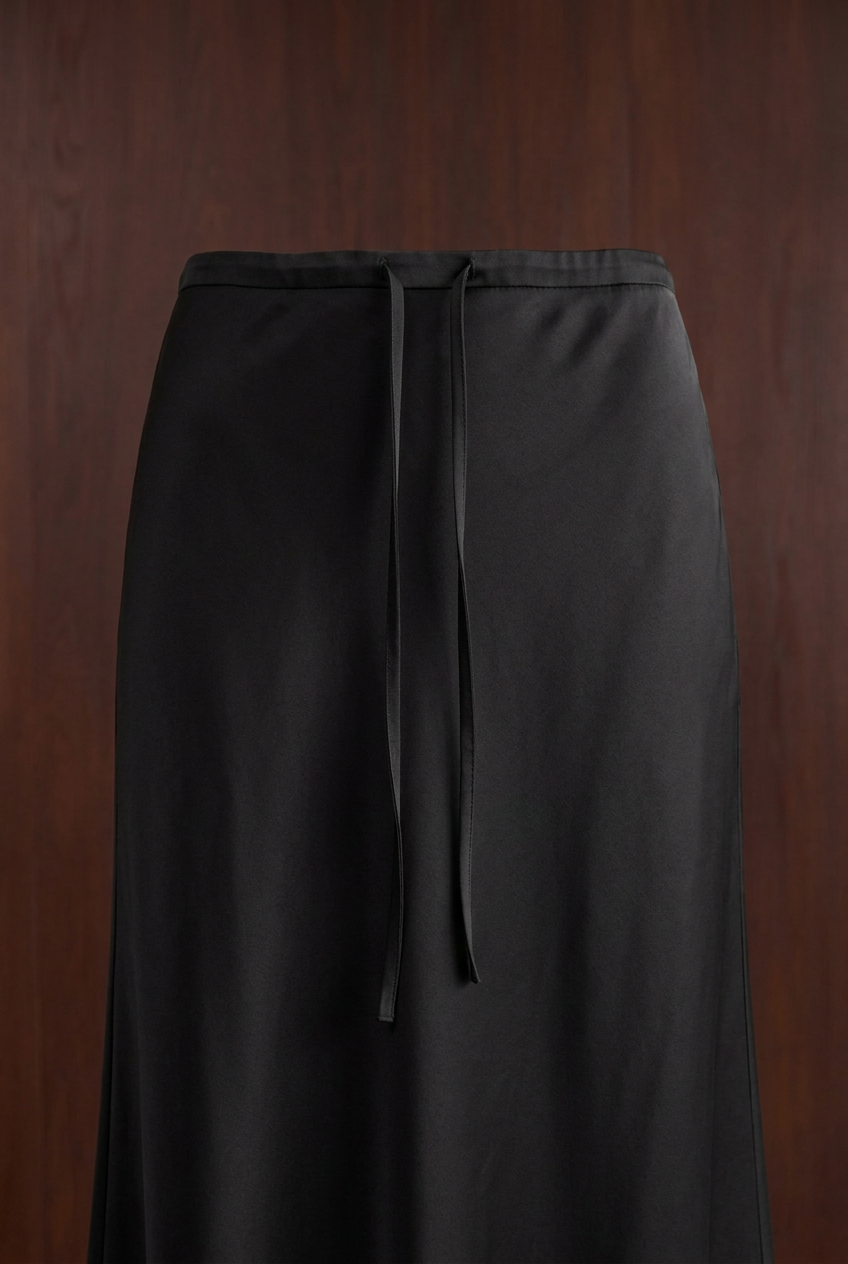 Detailfoto zwarte satijnen rok met trekkoord